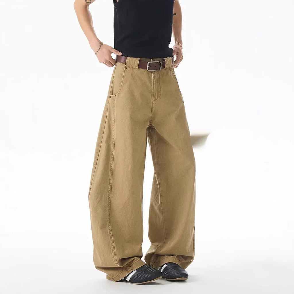 Brown loose-fit men's denim jeans with a straight leg and button fly on a neutral background.