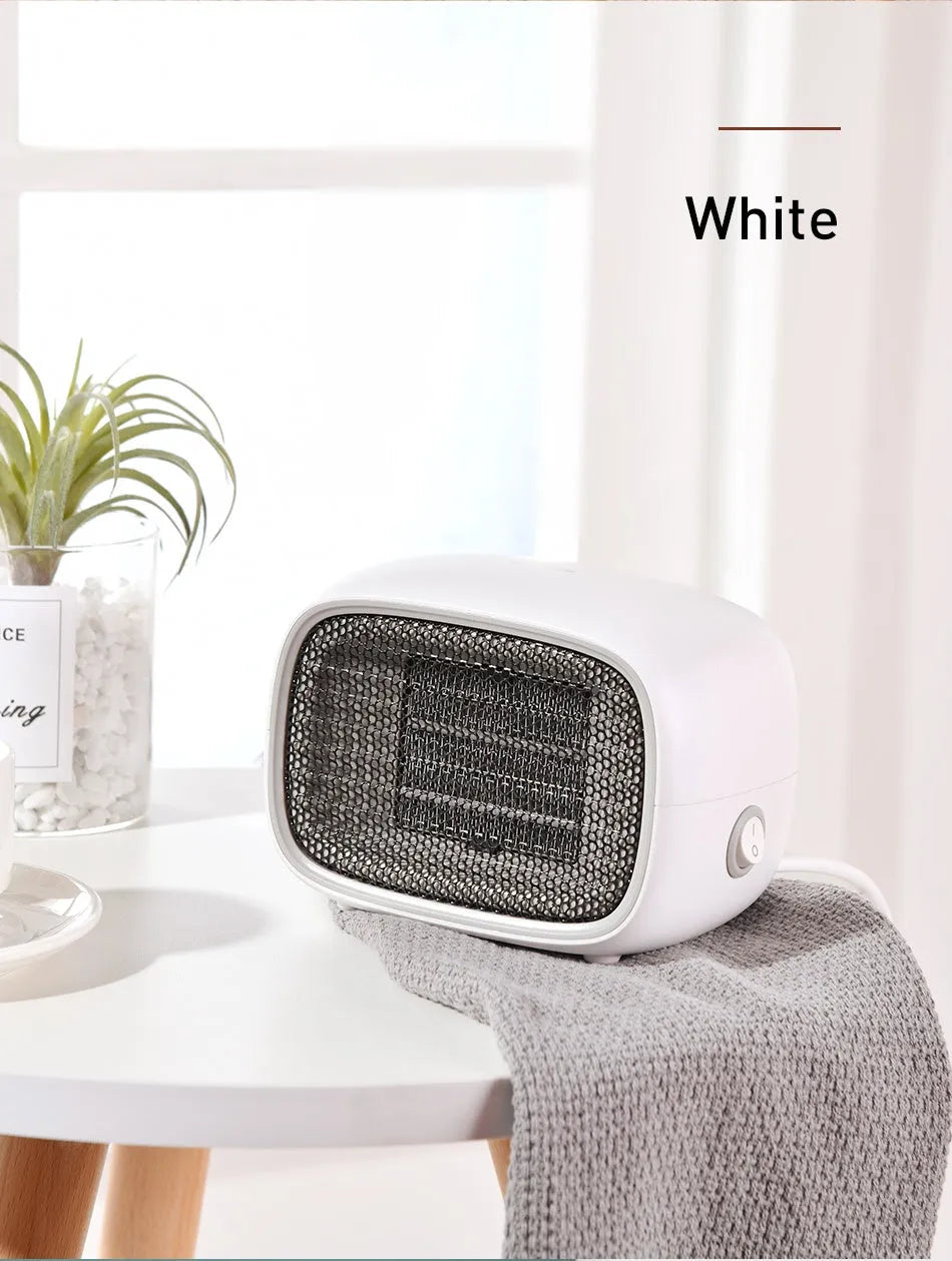 Green, white and yellow mini personal space heater on a desk showing compact size.