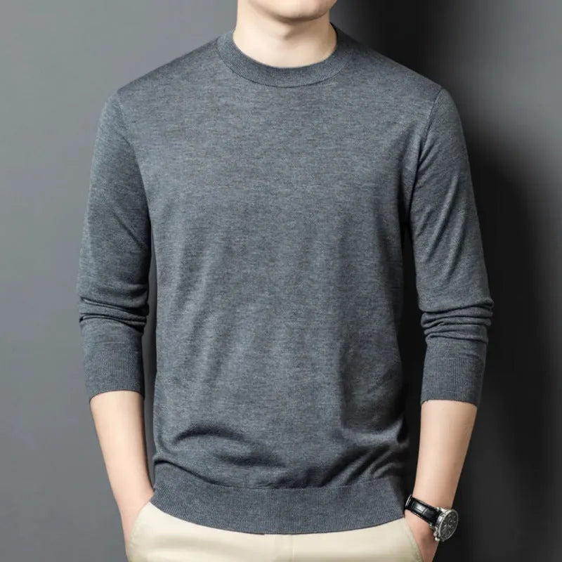 Man wearing a round neck long sleeve wool blend pullover sweater in a neutral colour.