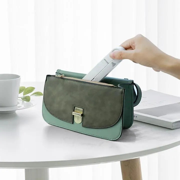 Black foldable tablet holder standing upright with a tablet device resting on its non-slip rubber surface.