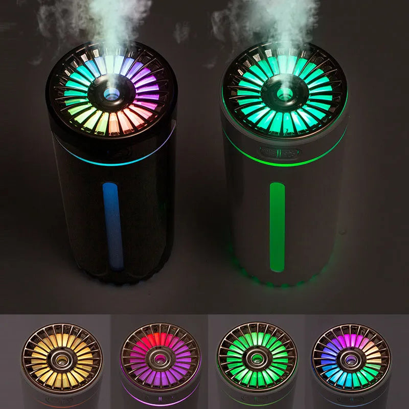 Black portable ultrasonic humidifier with colourful LED lights, shown next to a USB cable on a desktop.