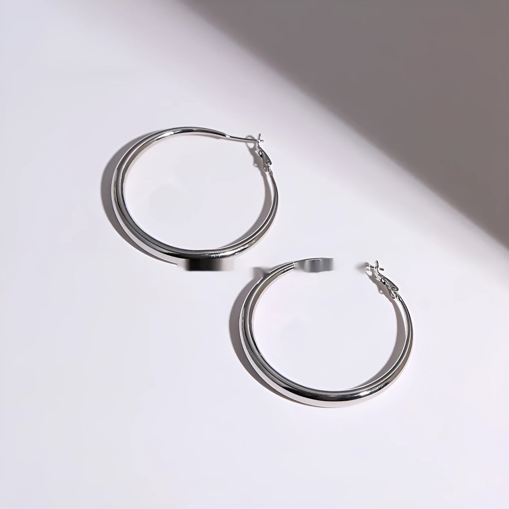 Silver needle big circle bracelet and earrings set with electroplated platinum finish on light background, three size options