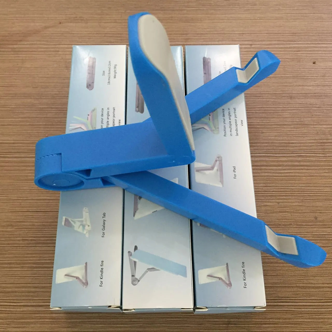 Black foldable tablet holder standing upright with a tablet device resting on its non-slip rubber surface.