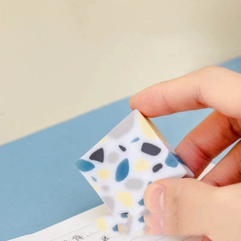 White brick-shaped rubber eraser on a flat surface.