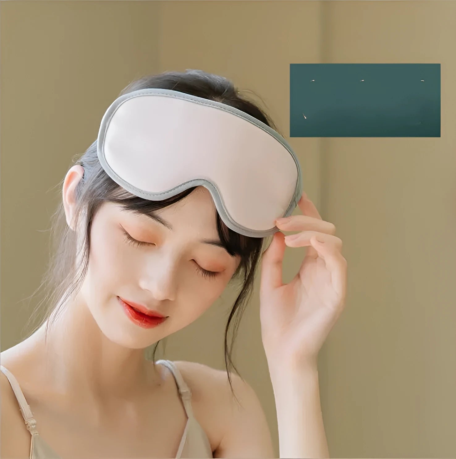 Green portable eye SPA massage goggles with USB cable on a grey background.