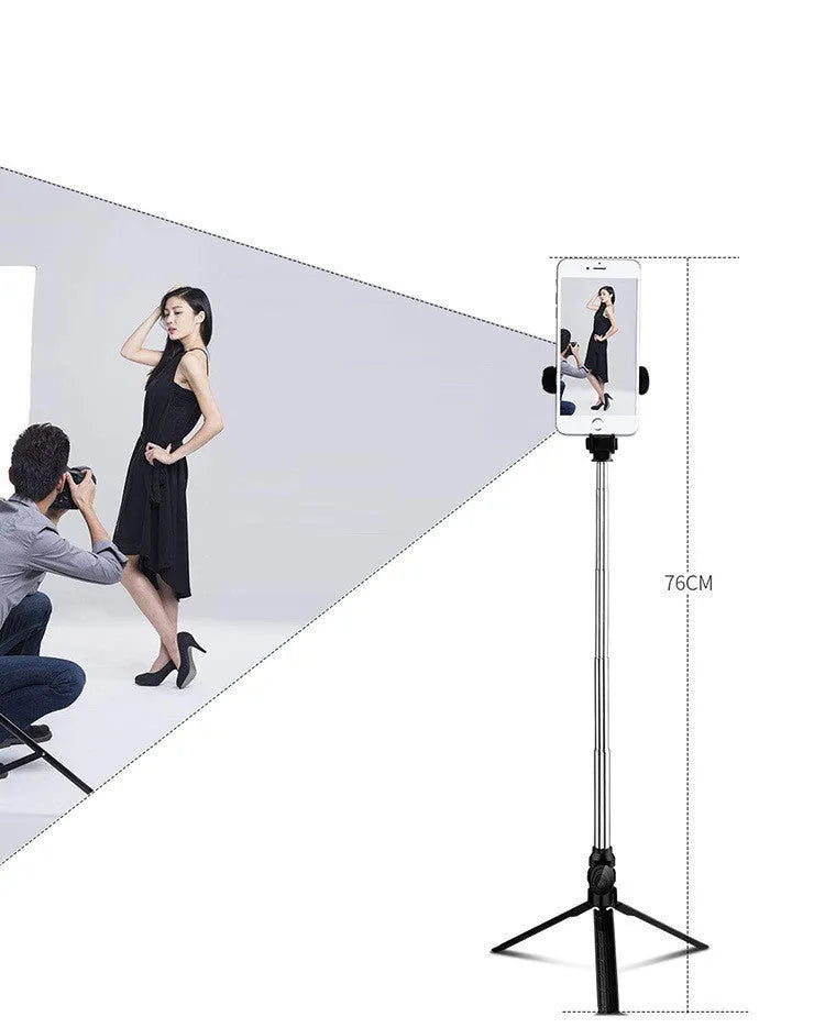 Black Bluetooth selfie tripod with extended stand and 360-degree rotating phone clip attached to an iPhone.