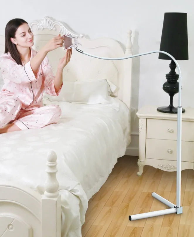 Black mobile phone bed bracket mounted on bedside with phone secured in universal folder for hands-free viewing