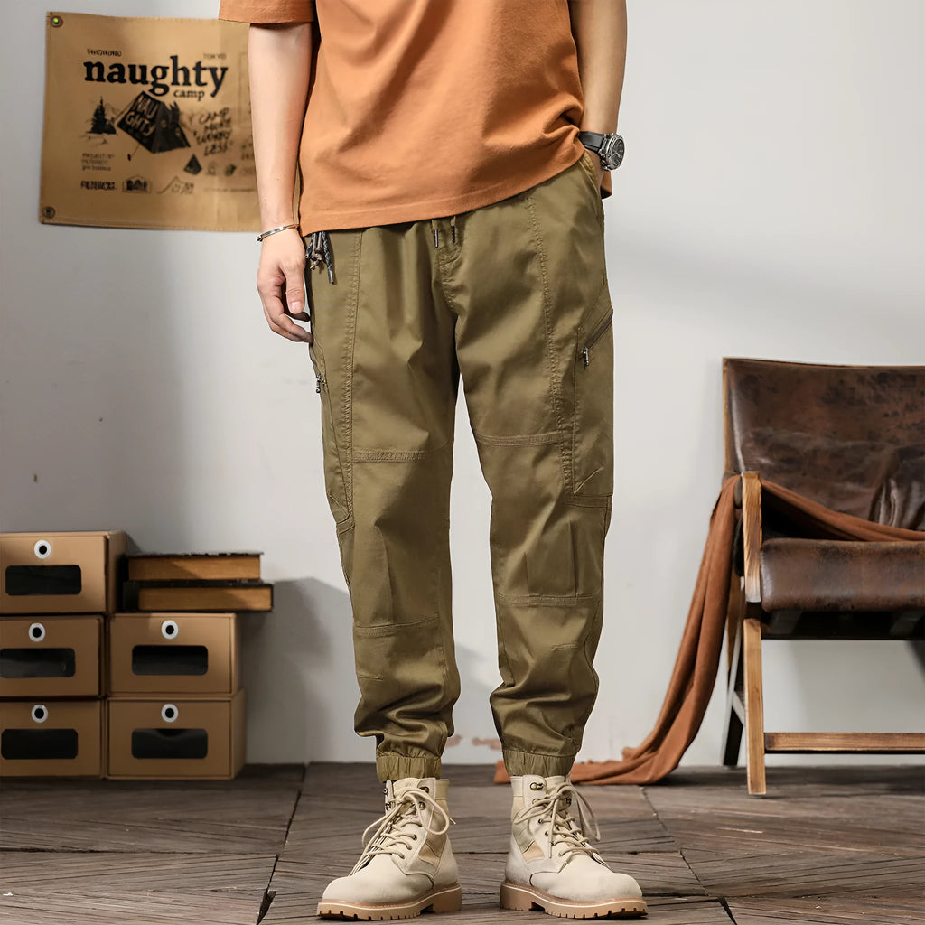 Men's khaki cotton harem pants with tapered ankle bands and a mid-waist zip fly.