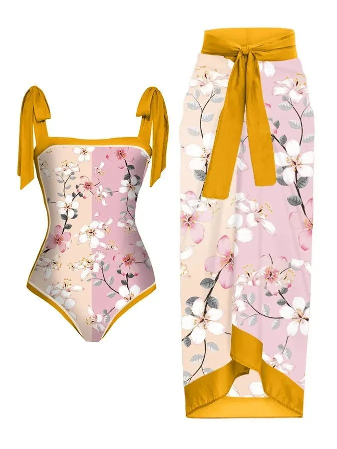 Women's floral print two-piece swimsuit with a blue chiffon skirt laid flat.