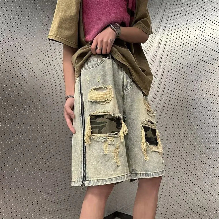 Men's yellow mud camouflage ripped denim shorts shown on a model, featuring a straight leg cut and distressed details.