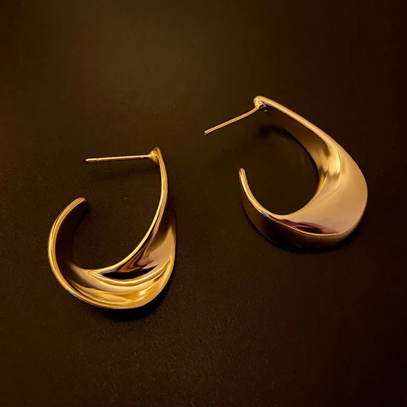 Metal geometric twisted earrings with round elements in gold or silver electroplated finish