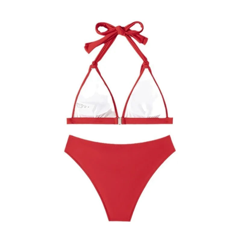 Red women's lace-up halterneck bikini top and matching shorts on a plain background.