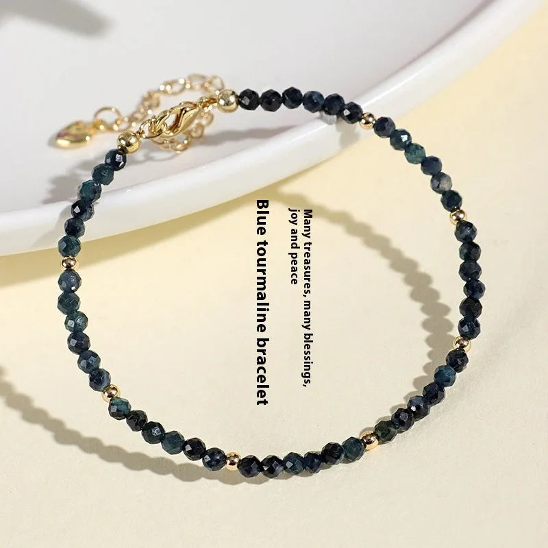 Close-up of a women's blue tourmaline beaded bracelet with 3mm beads and spacer sections.