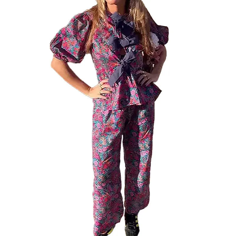Women's floral print trouser suit set featuring a puff sleeve top with tie-neck and matching trousers.