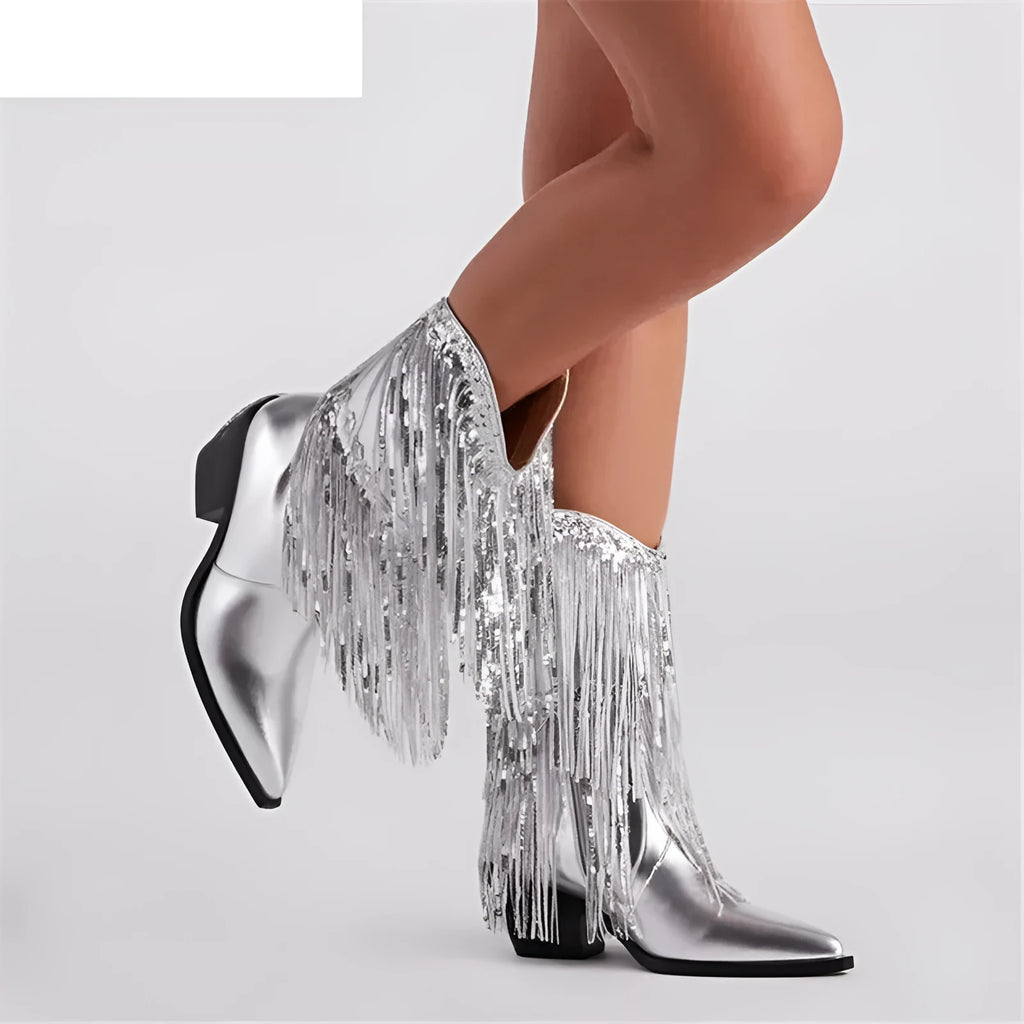 Women's black chunky heel tassel boots with a pointed toe and a high stiletto heel on a fashion runway.
