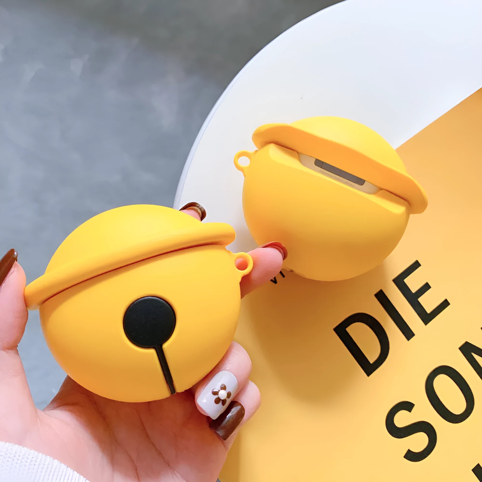 Yellow bell-shaped silicone protective case for AirPods 1 and 2 generation headphones.
