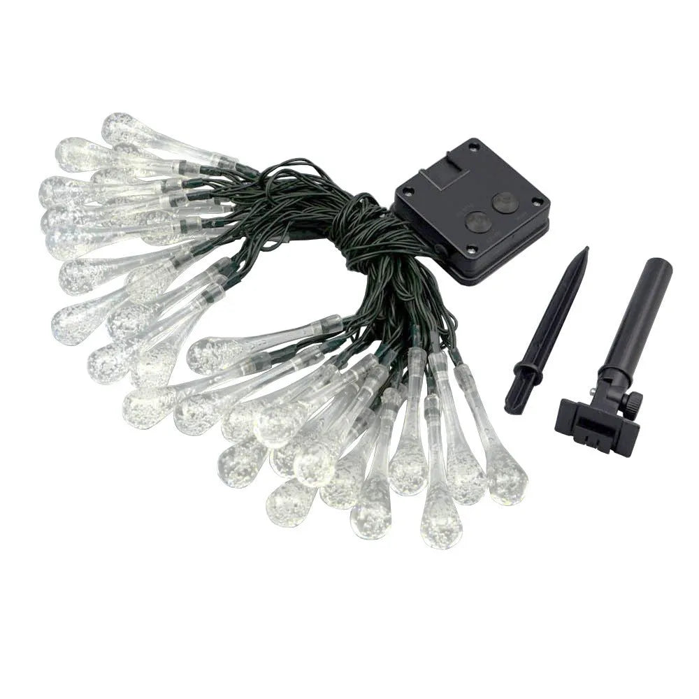 Solar-powered LED outdoor string lights with bubble drop pendants decorating a garden fence