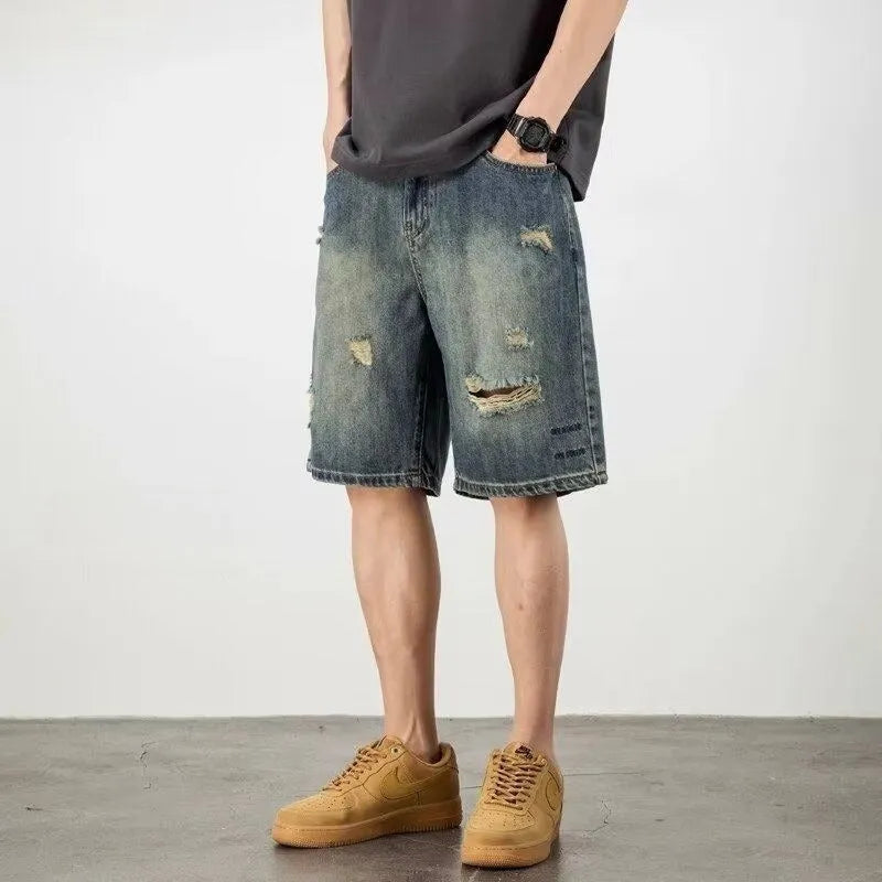 Men's blue denim shorts with loose hole distressing and straight leg silhouette