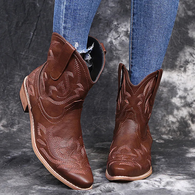 Blue women's cowboy boots with white embroidery, a low wedge heel, and a pointed toe