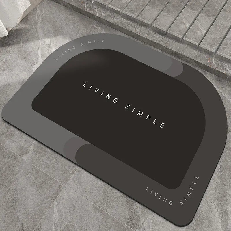 Grey oval super absorbent polyester bath mat with non-slip rubber bottom on tiled floor