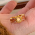 Geometric open ring for women with pink crystal enamel detail on a gold-plated copper band.