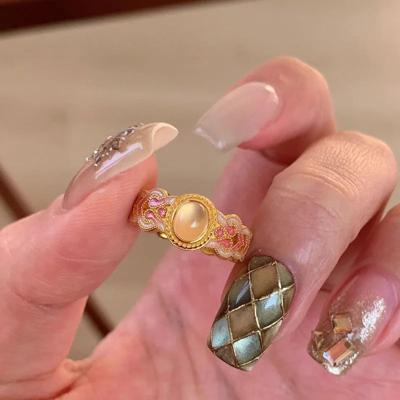 Geometric open ring for women with pink crystal enamel detail on a gold-plated copper band.