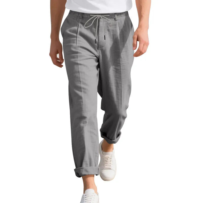 Men's light beige linen casual trousers with drawstring waist and straight-leg fit on a hanger.
