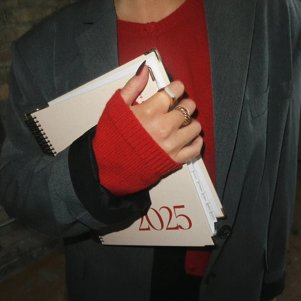 Cherry red coil notebook with daily schedule layout and spiral binding