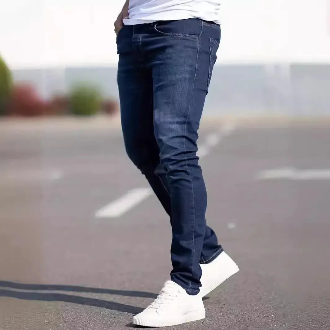 Men's dark blue slim fit skinny jeans with a mid waist and zipper fly, laid flat.