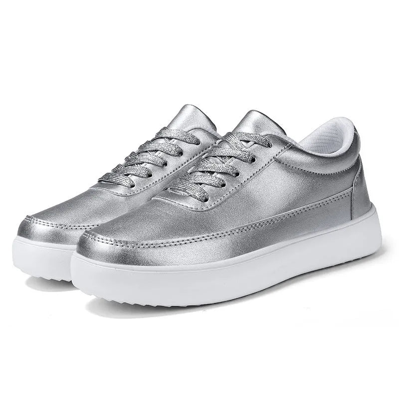 Women's white leather flat casual shoes with lace-up front on a plain background.