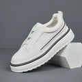 Black leather low-top slip-on sneaker with elastic sides and foam sole on white background