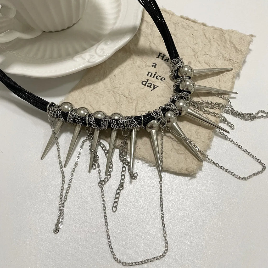 Women's leather necklace with round beads, a winding tassel, and metallic point rivets.