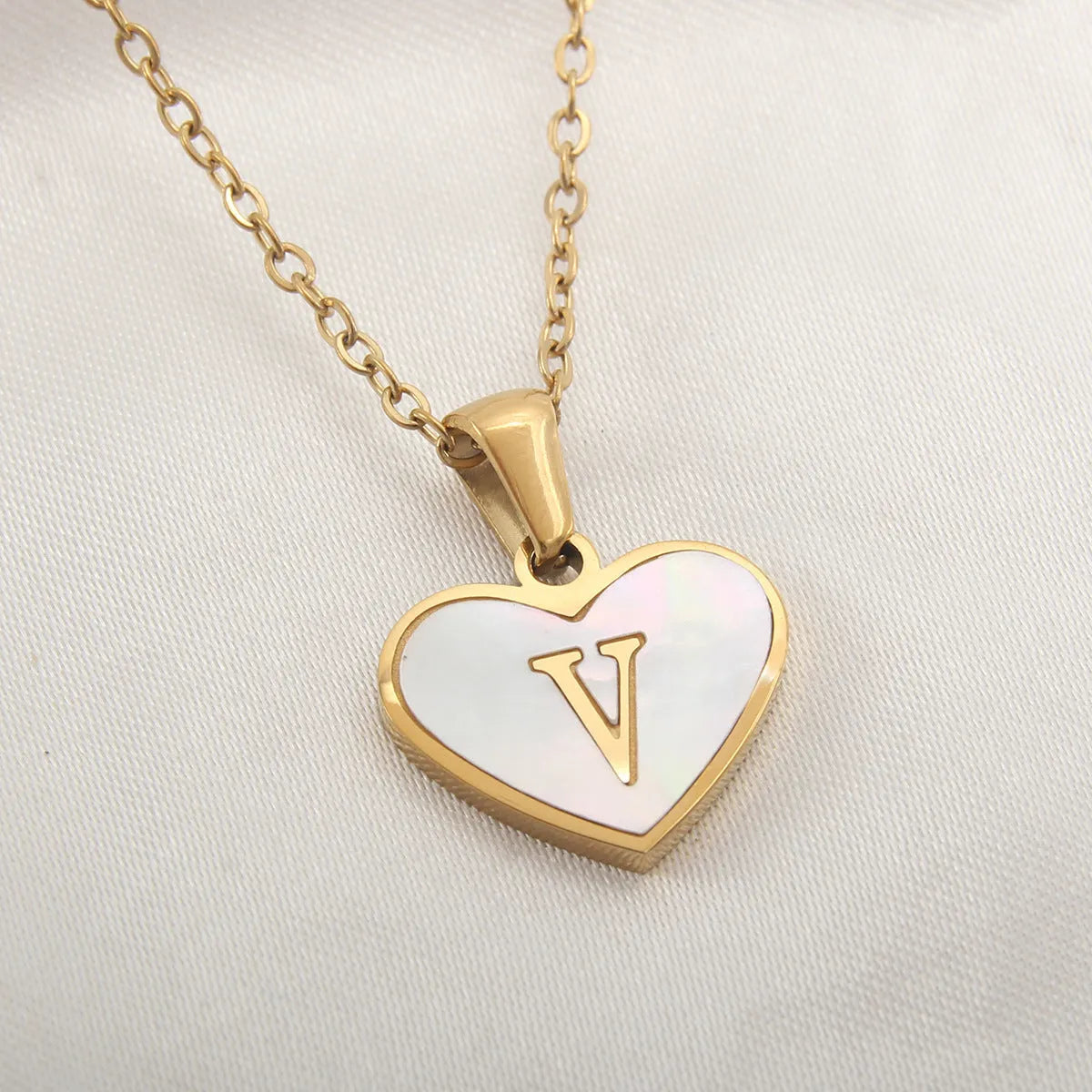 Gold heart necklace with white shell detail and personalised initial letter on adjustable chain
