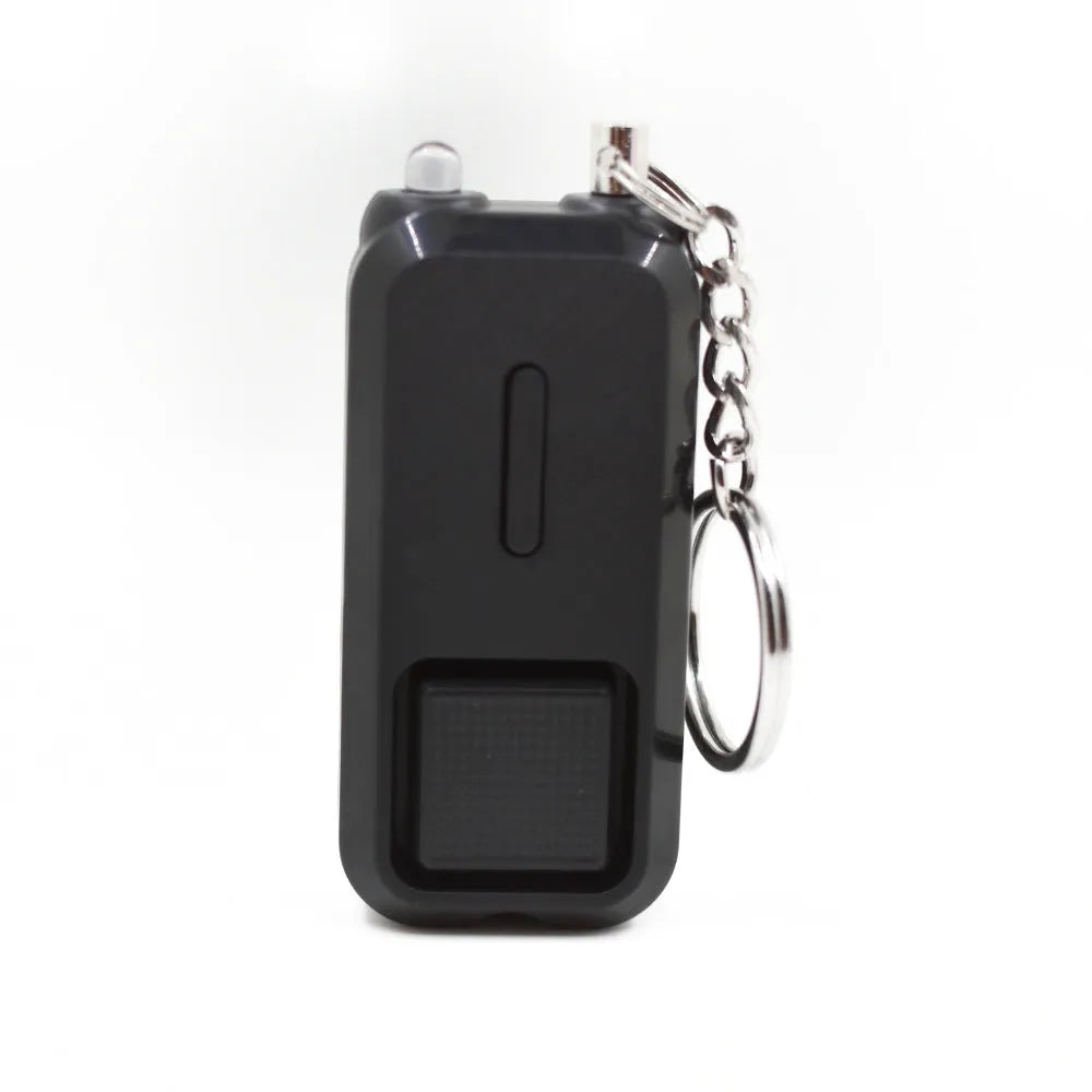 Compact pink personal safety alarm with keyring, showing dimensions next to a ruler.