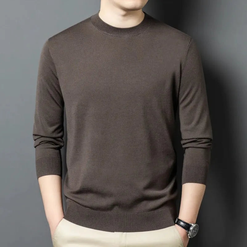 Man wearing a round neck long sleeve wool blend pullover sweater in a neutral colour.