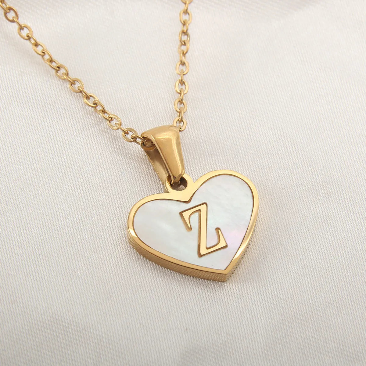 Gold heart necklace with white shell detail and personalised initial letter on adjustable chain