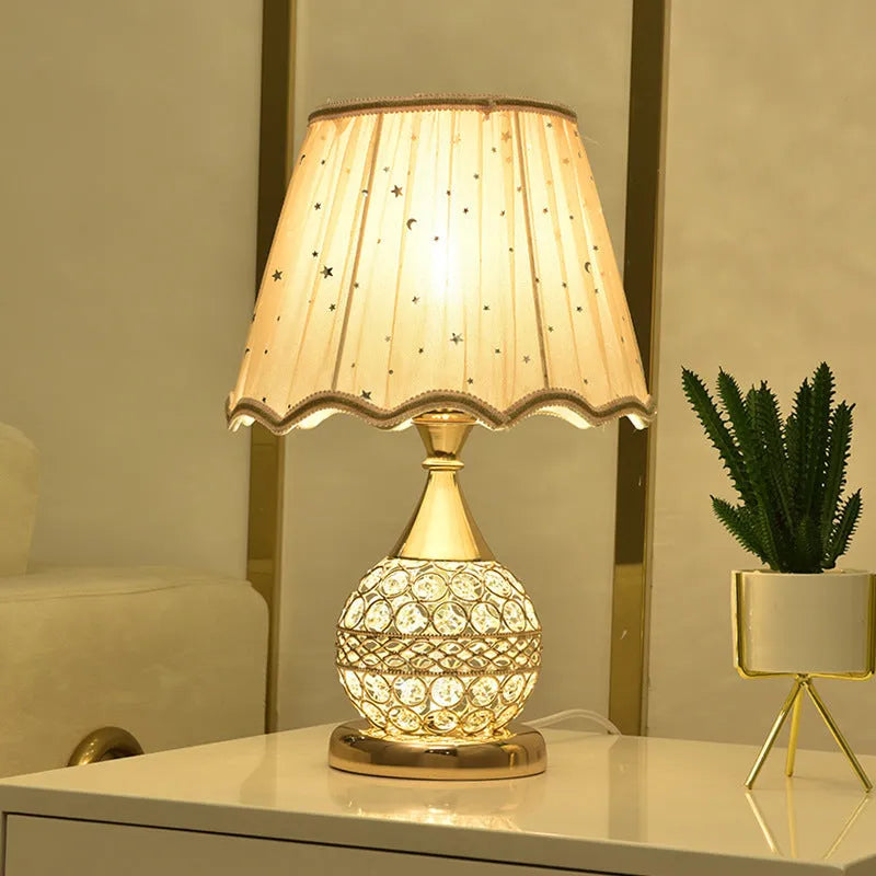 Gold crystal desk lamp with iron art base on a wooden table