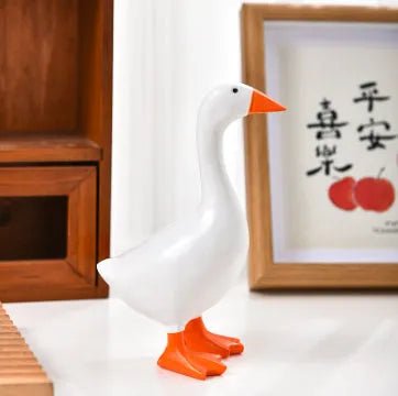 White simulation duck resin magnetic ornament on metal surface holding a note
