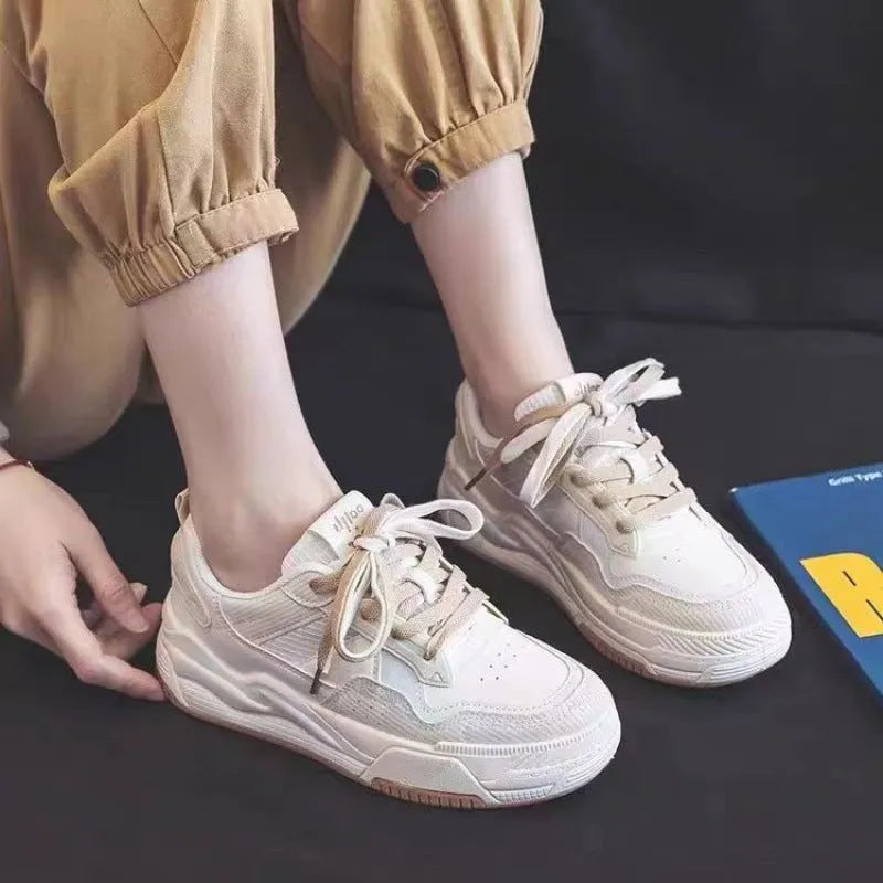 Pink and beige low-top sneakers with a rubber sole and imitation leather upper.