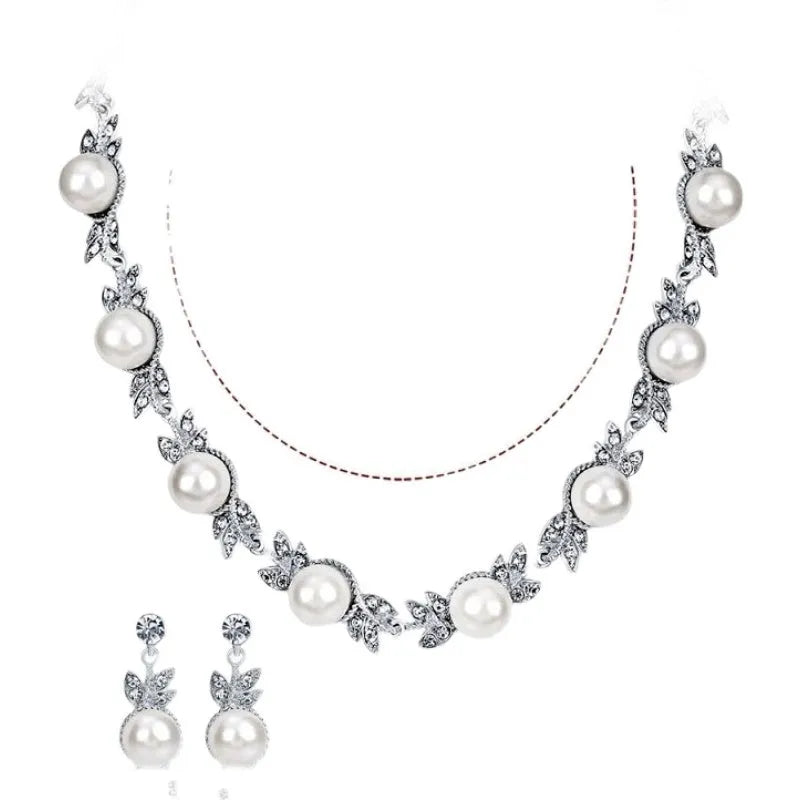 Three-piece jewellery set with rhinestone and pearl necklace, earrings, and bracelet in silver finish