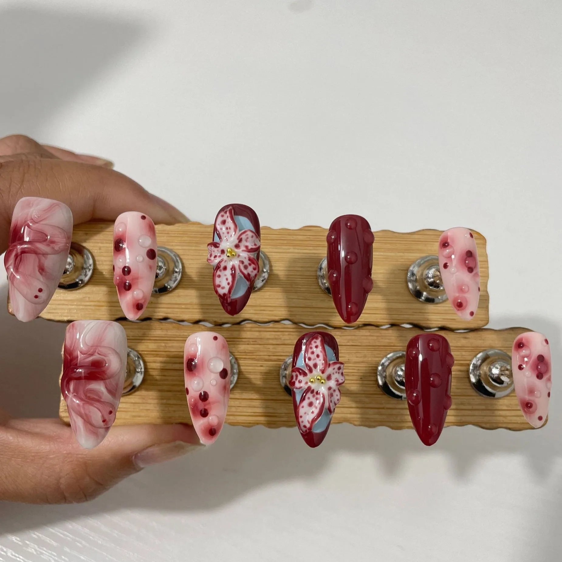 Almond-coloured false nails with hand-painted three-dimensional rose and tulip floral designs