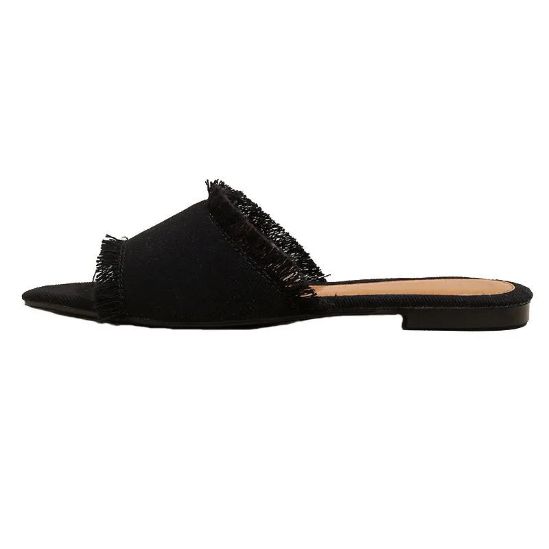 Women's casual denim flat slippers with leather lining and tassel detail.