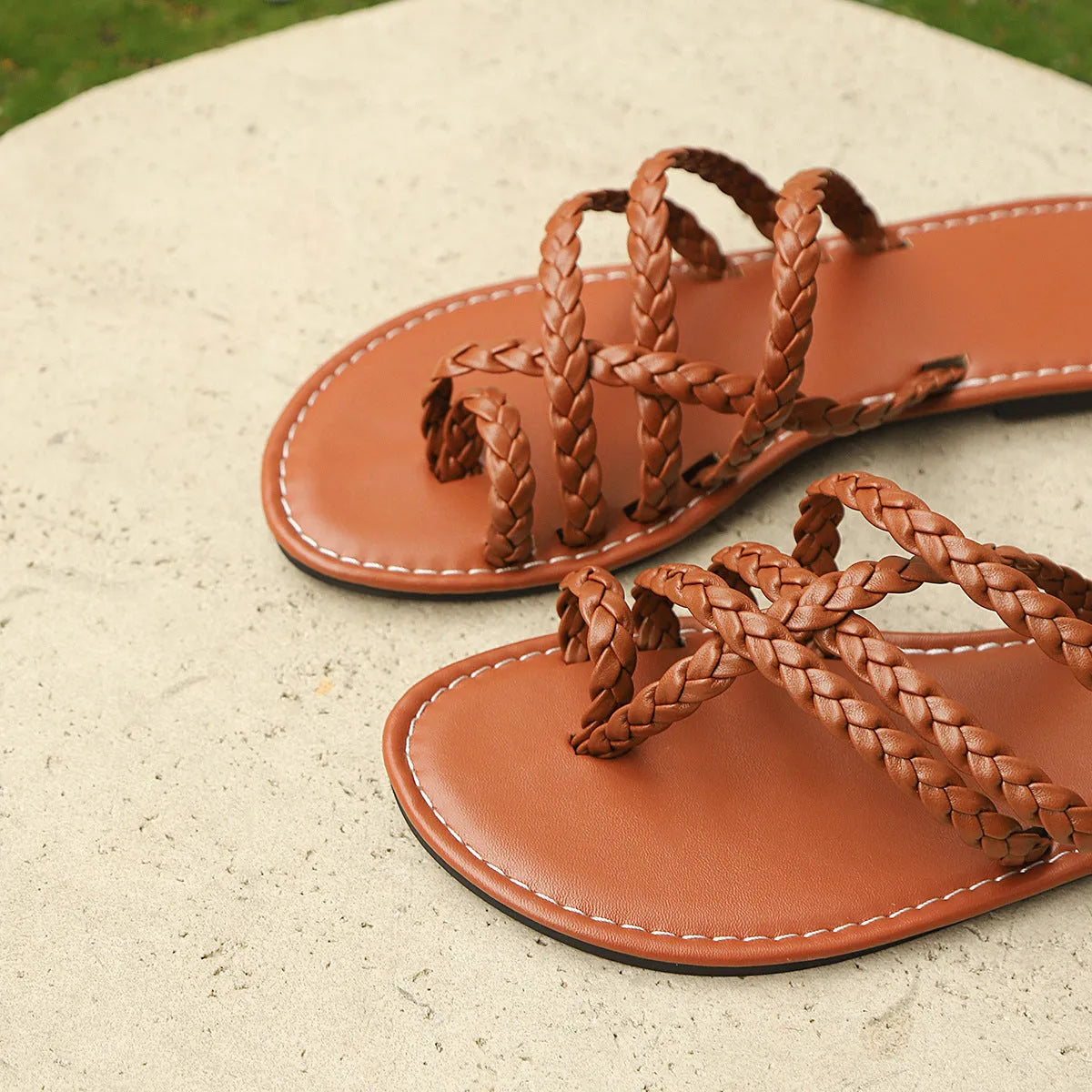 Women's white clip-toe woven flat sandals with a Roman design and rubber sole.