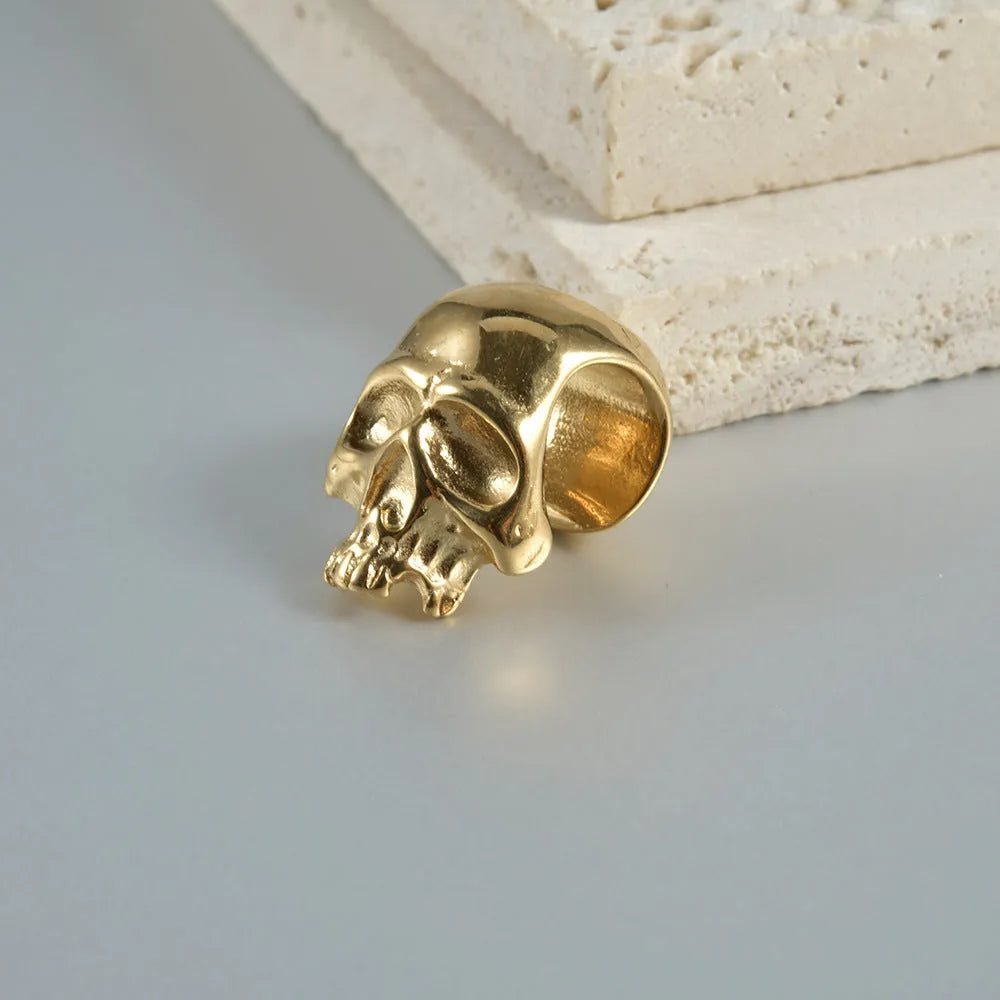 Geometric stainless steel earrings combining hollow skull and Buddha motifs with electroplated finish