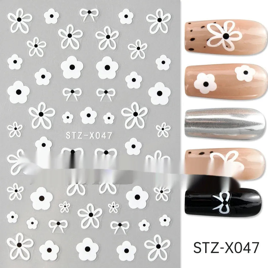 Close-up of a cartoon-style nail sticker with black and silver strips and a love pattern design on a fingernail.