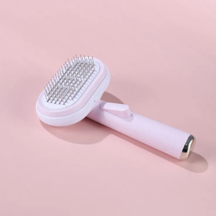 Blue and pink pet hair removal brush with steel needles on a light background