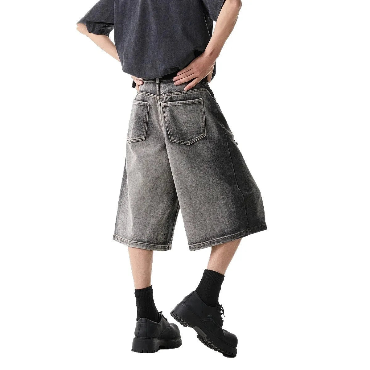 Gray distressed denim shorts with hole detailing, loose cropped fit on a plain background.