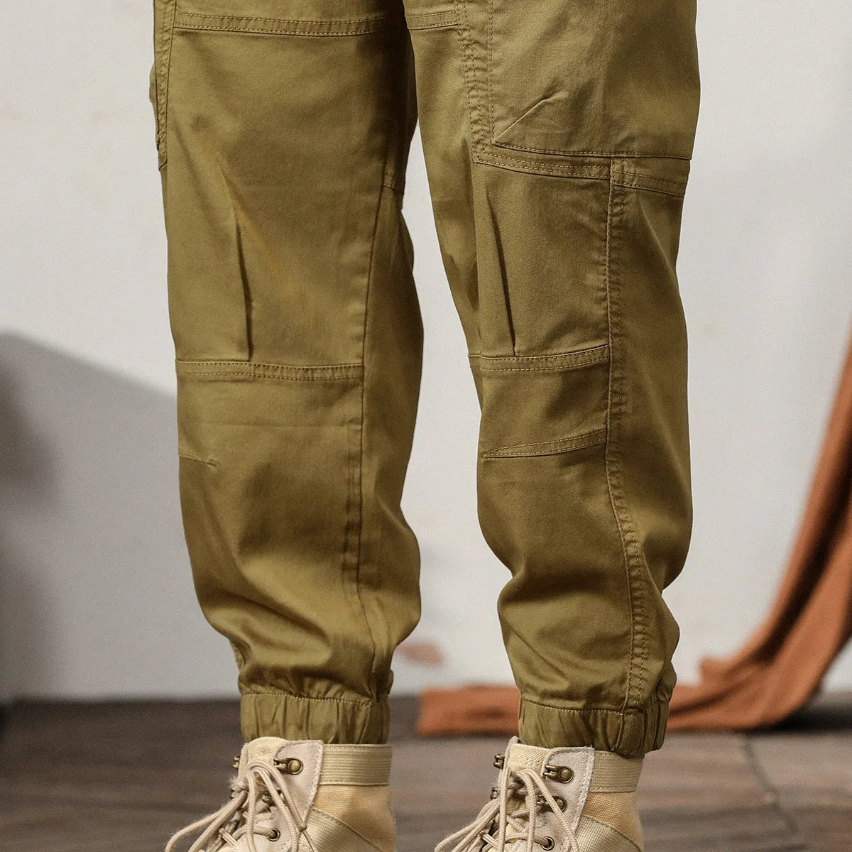 Men's khaki cotton harem pants with tapered ankle bands and a mid-waist zip fly.