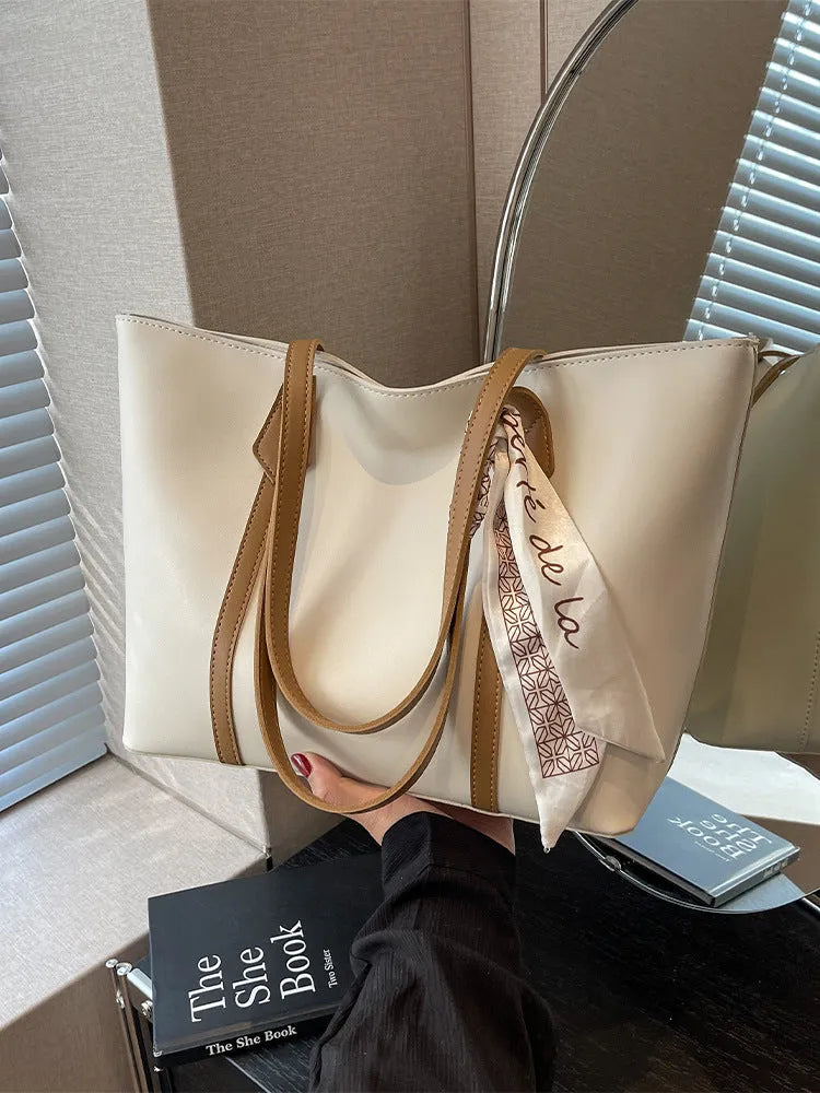 Large casual tote bag with bucket shape showing internal zippered pocket and sewing line detailing