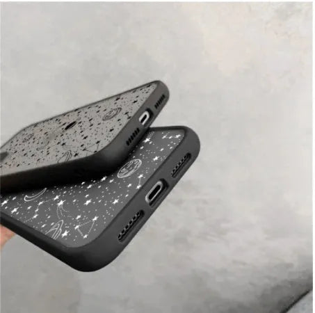 Black and white Star Universe anti-blue light phone case for iPhone models on a table.